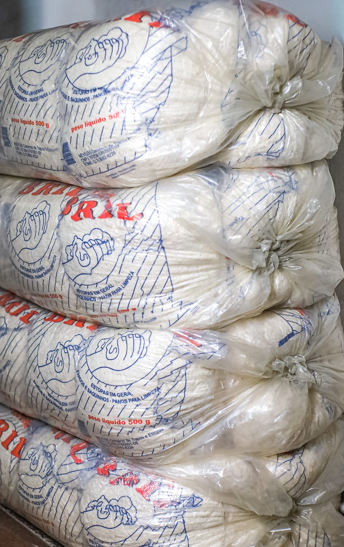 Pacotes de estopa branca Bril de 500 g empilhados em estoque